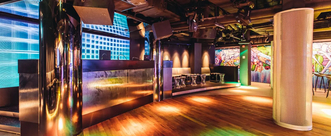 A club floor with orange spotlights and coloured walls