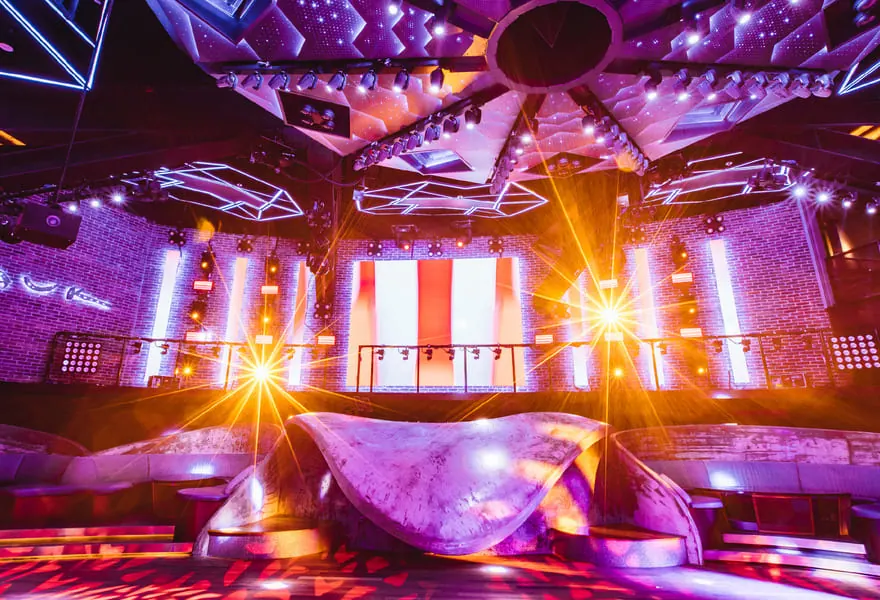 A lit stage and lasers over a crowd at Zouk
