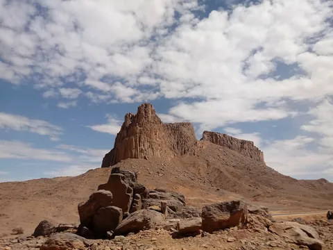 A rocky peak and boulders under a cloudy sky in the Hoggar