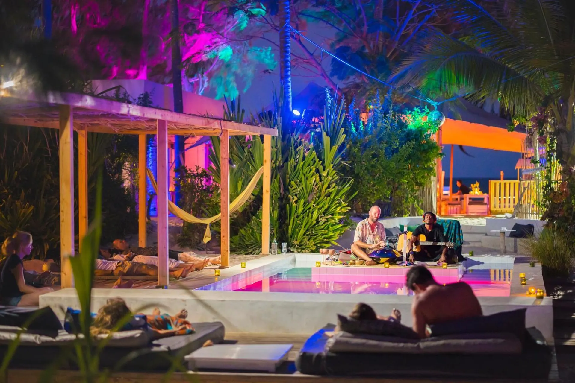 A poolside lounge with hammocks and coloured lights at B4 Beach