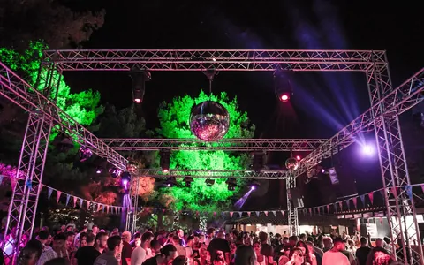 A stage rig lit green with a crowd in front, at Barbarella's