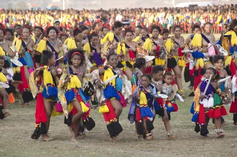 A large crowd of dancers in red, yellow and blue costumes