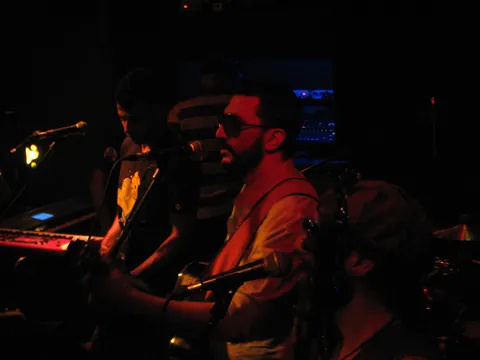 A musician at the keyboard in a dark club