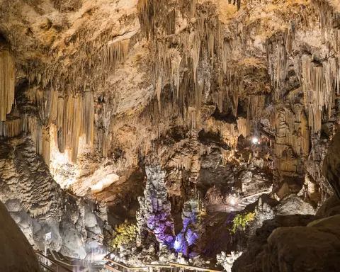 Stalactites and rock formations in a cavern lit from below at Nerja
