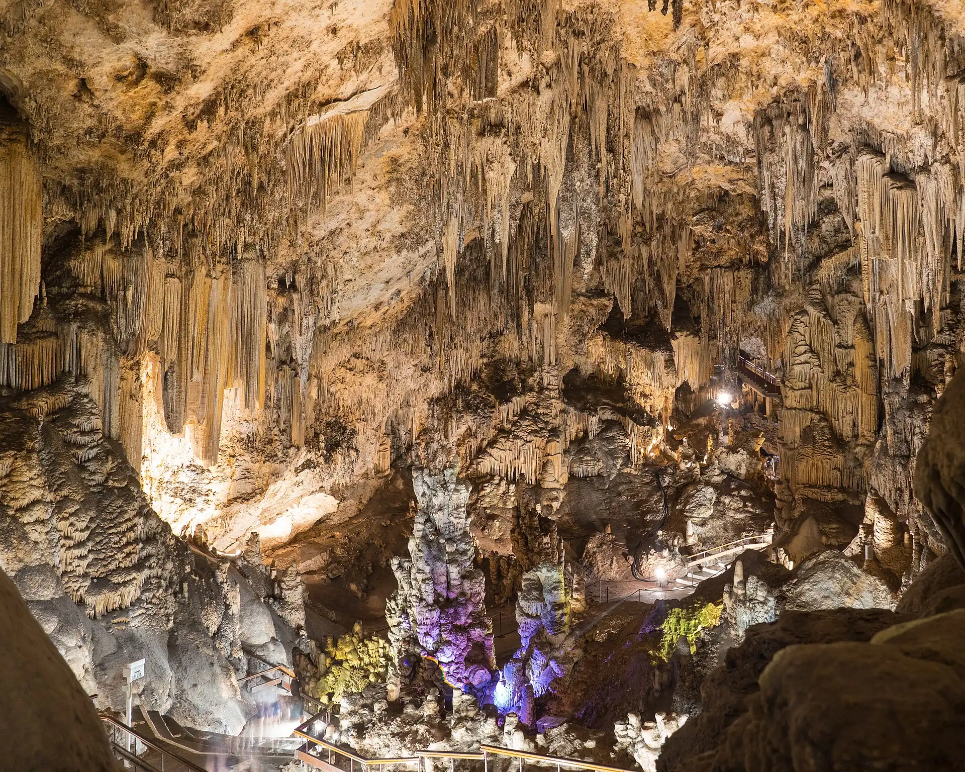 Stalactites and rock formations in a cavern lit from below at Nerja