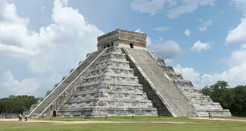 El Castillo pyramid at Chichén Itzá under a partly cloudy sky