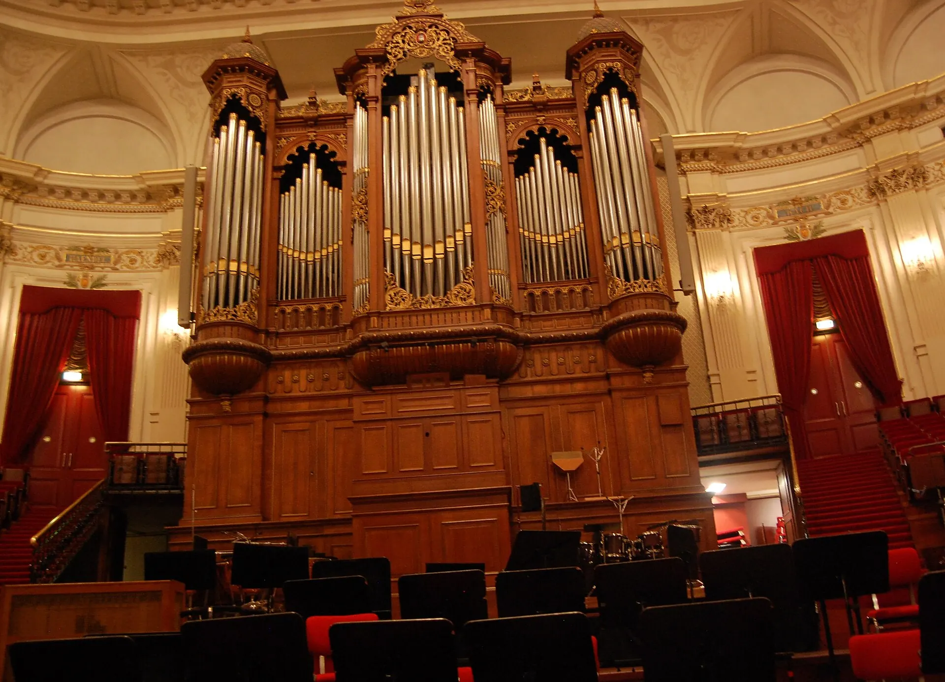 The gilded organ and pipes of the Concertgebouw Main Hall, flanked by red-curtained doorways