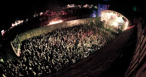 A crowd in the Pula Roman amphitheatre at a Dimensions opening concert, from the festival's Pula years before the move to Tisno