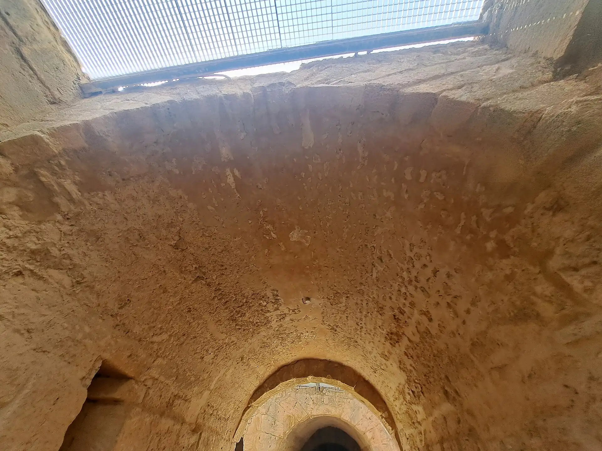 A vaulted stone passage in the El Jem amphitheatre, lit from an opening above