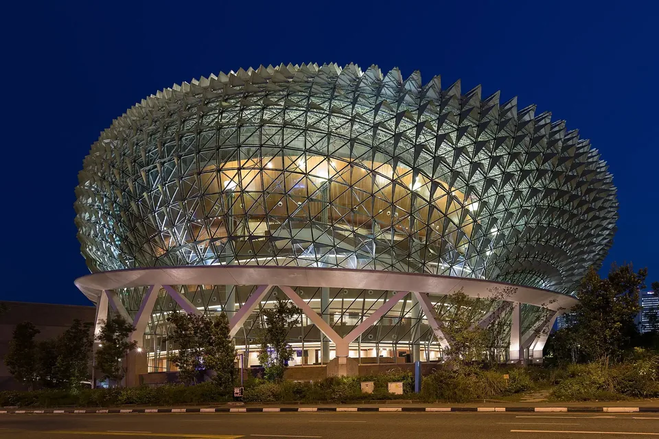 The spiky glass domes of the Esplanade lit blue at dusk