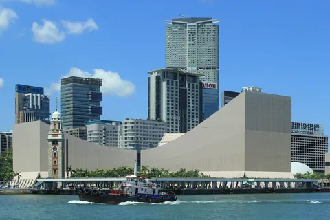 The Hong Kong Cultural Centre beside the harbour with skyscrapers behind