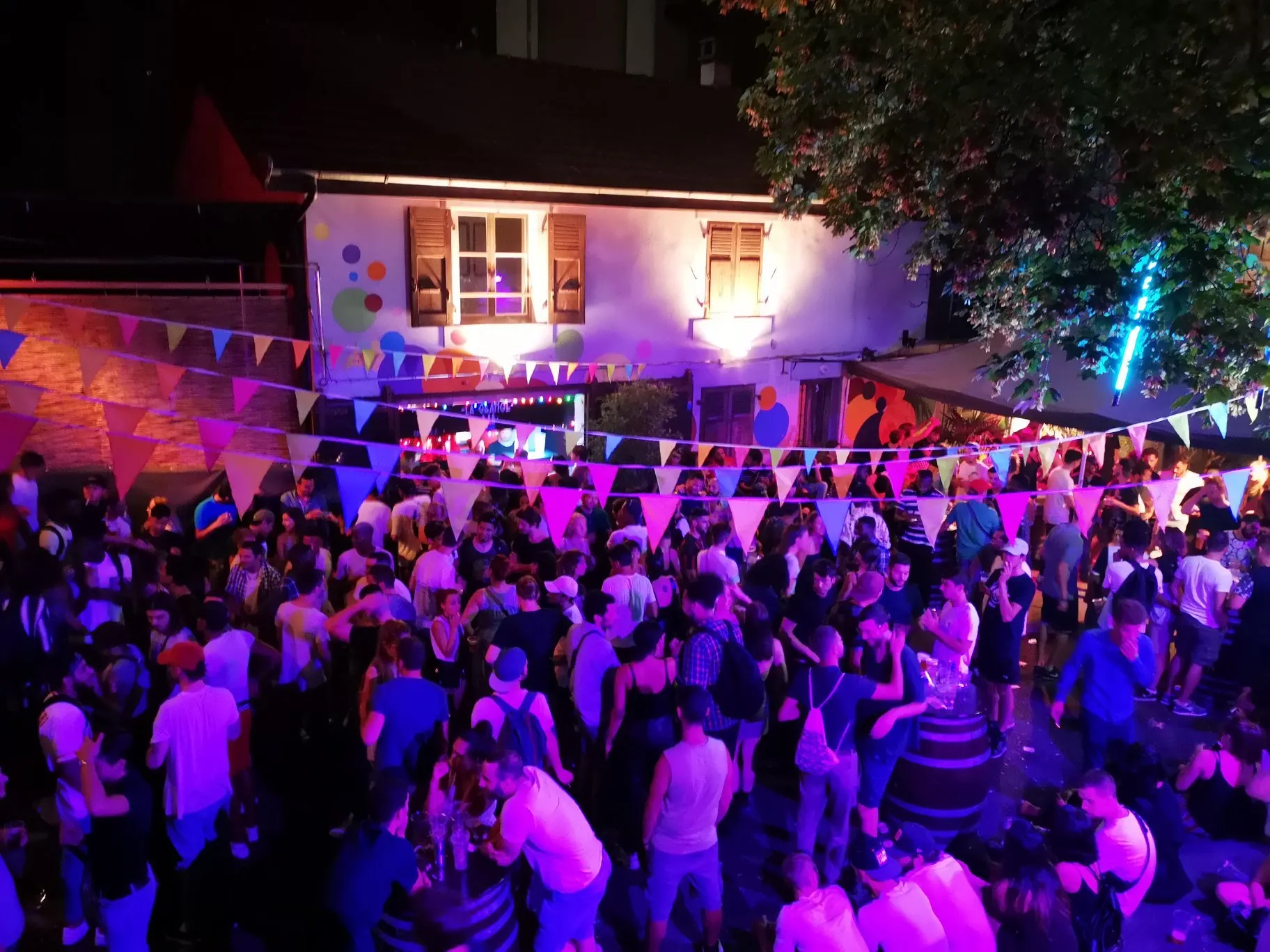 A crowd dancing in purple light at La Gravière