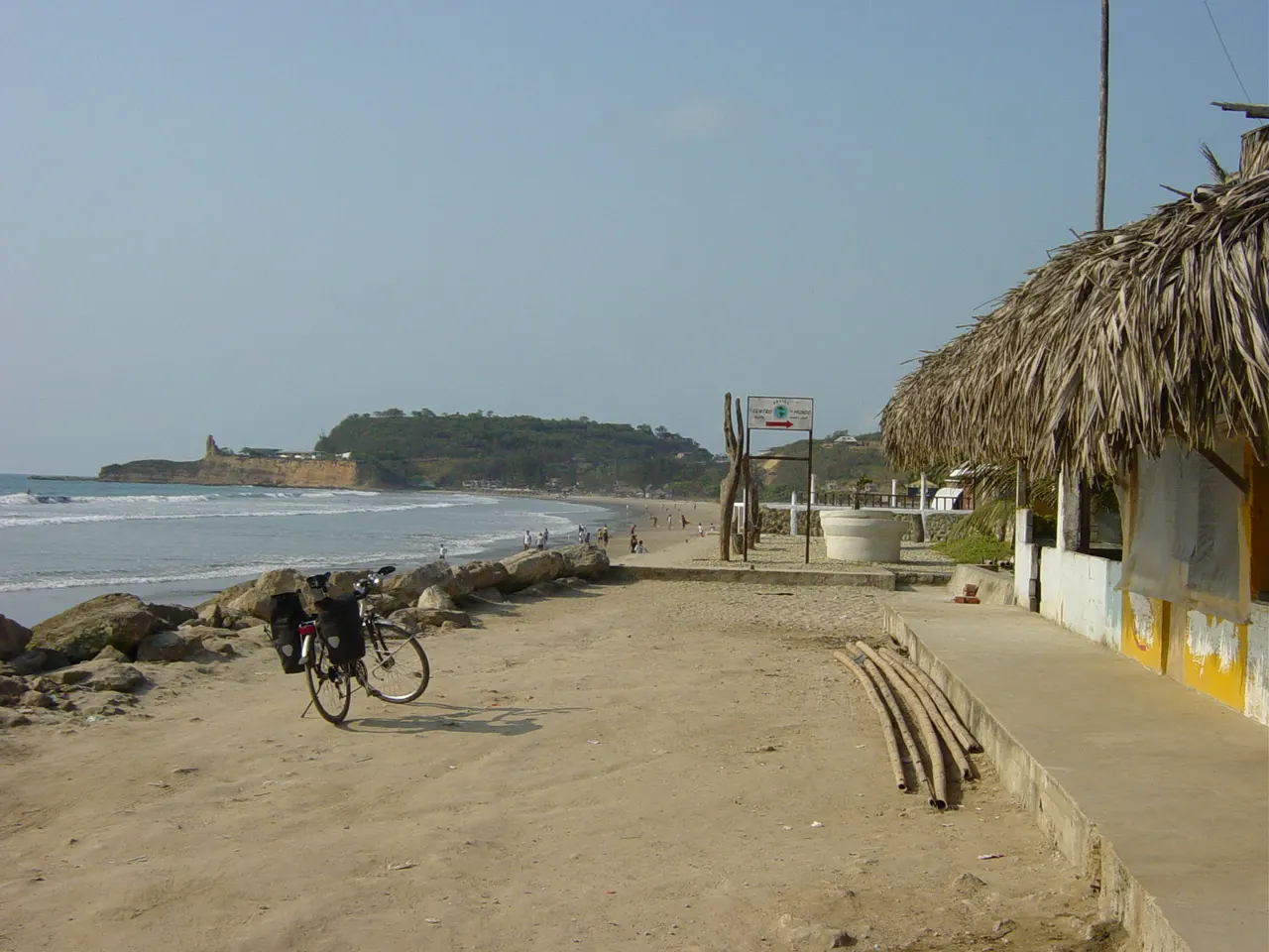 A palm-thatched beach hut on a sandy shore