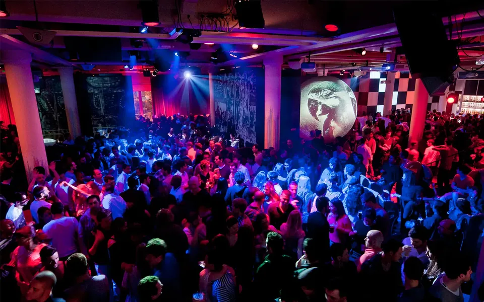A packed dancefloor at Lux Frágil under blue and magenta light