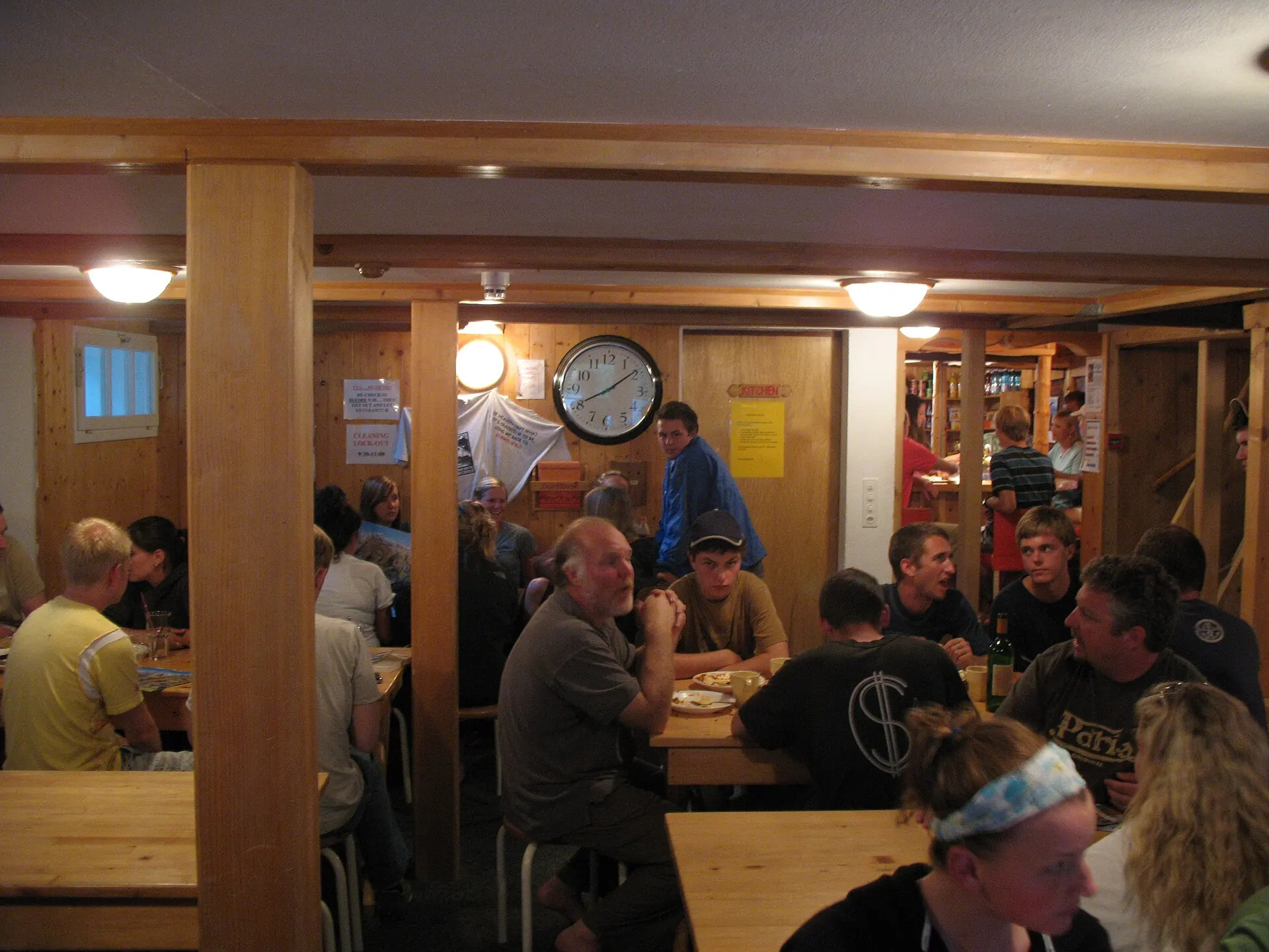Guests at wooden tables in the Mountain Hostel dining room in Gimmelwald