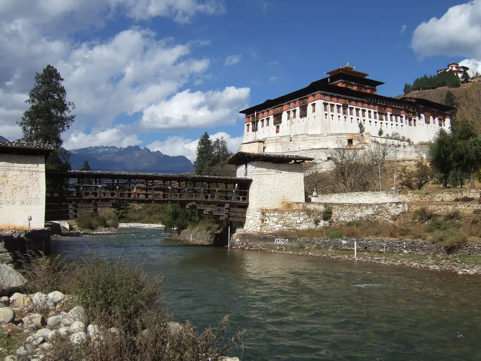 Rinpung Dzong above a covered wooden bridge and river in Paro