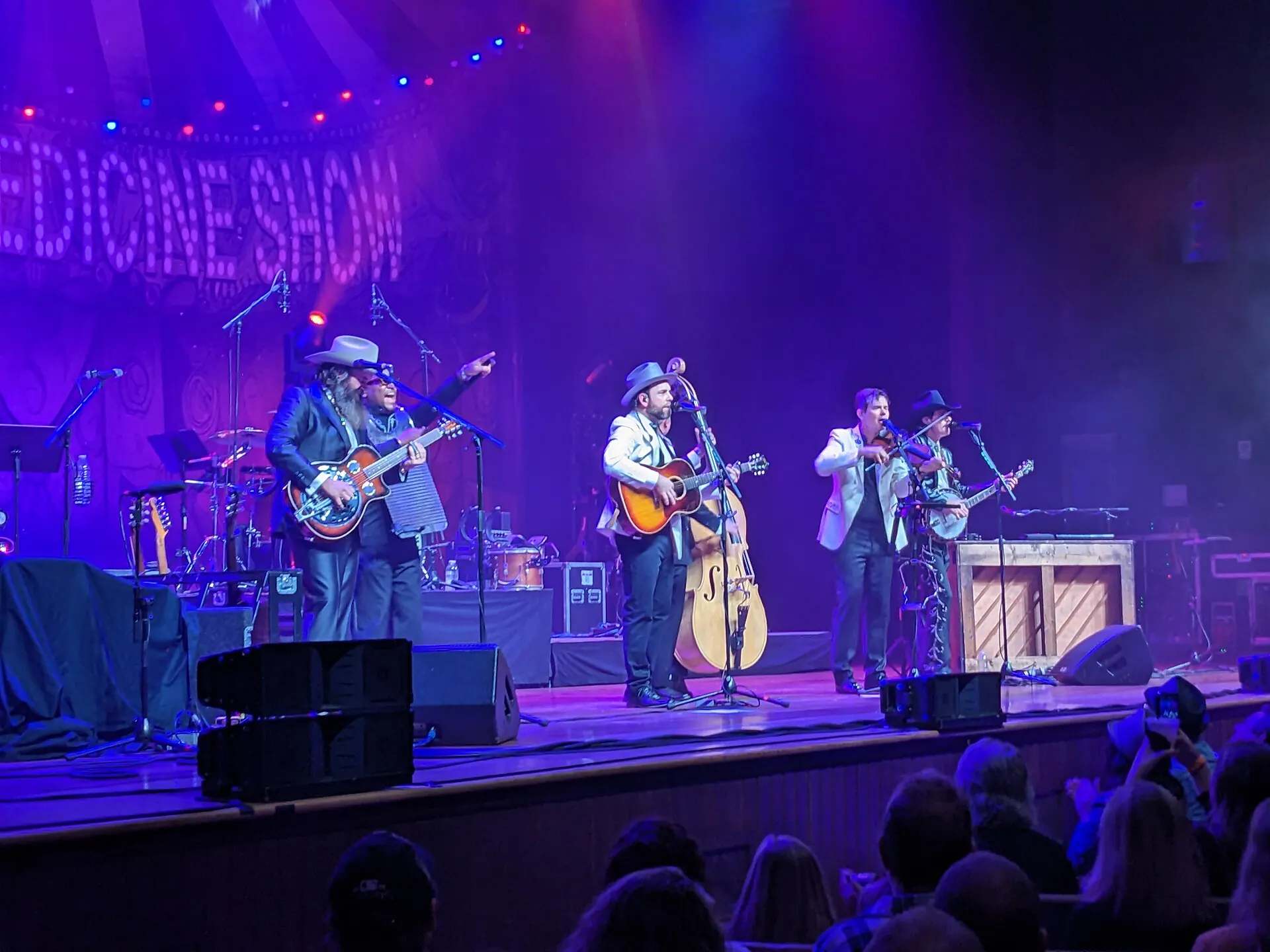 A band performing on the lit stage of the Ryman Auditorium