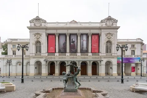 The classical facade of the Teatro Municipal de Santiago with banners between the columns