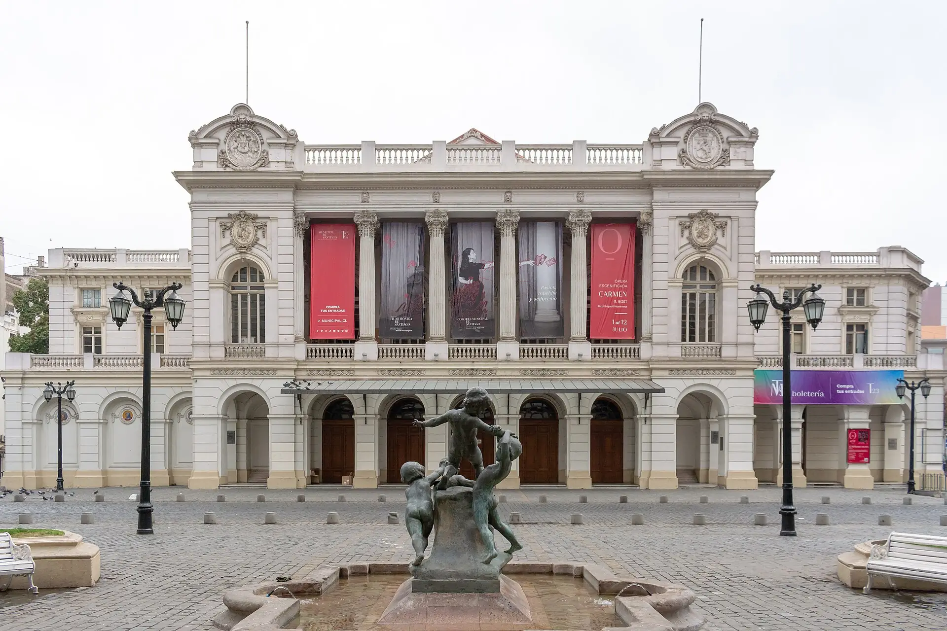 The classical facade of the Teatro Municipal de Santiago with banners between the columns