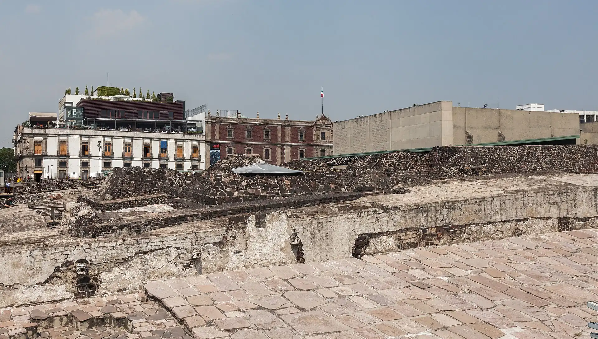 Excavated Aztec ruins of the Templo Mayor with colonial buildings behind