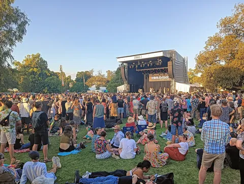 A crowd on the grass in front of a park stage at WOMADelaide