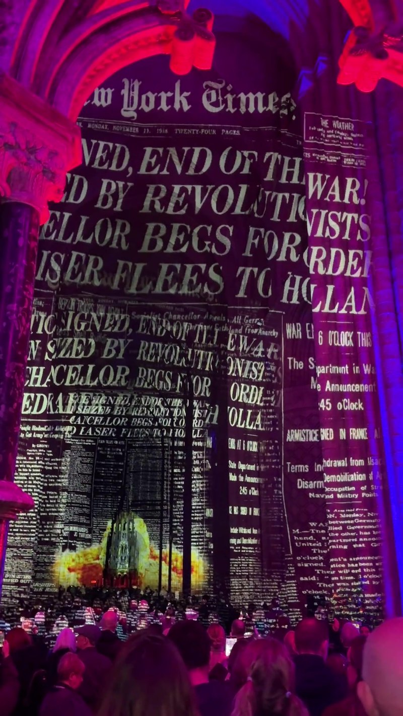 A New York Times front page of 11 November 1918, headlined END OF THE WAR, projected on the stone of Durham Cathedral's nave