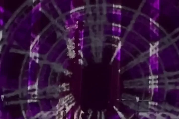 Clock faces falling down a tunnel of purple and white light projected along the nave of Durham Cathedral