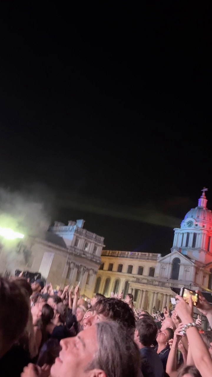 The two domes of the Old Royal Naval College lit for the show at night, the crowd below