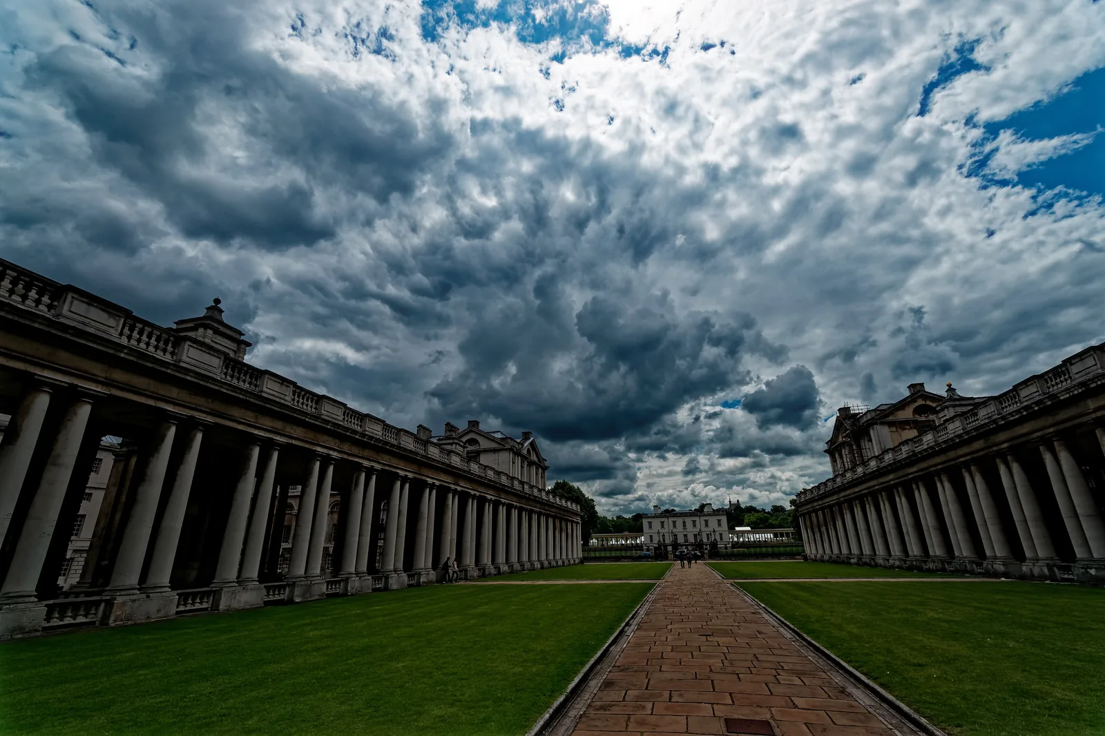 Grand Square at the Old Royal Naval College, empty: the colonnades of King William and Queen Mary Courts running towards the Queen's House under a heavy sky